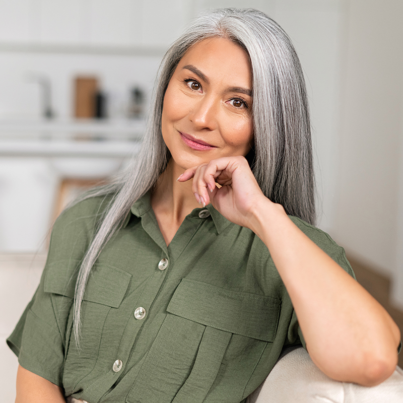 Close up portrait of charming middle aged woman with long silver hair sitting in relaxed athmosphere