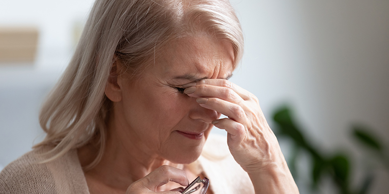 Tired upset middle aged woman taking off glasses rubbing eyes
