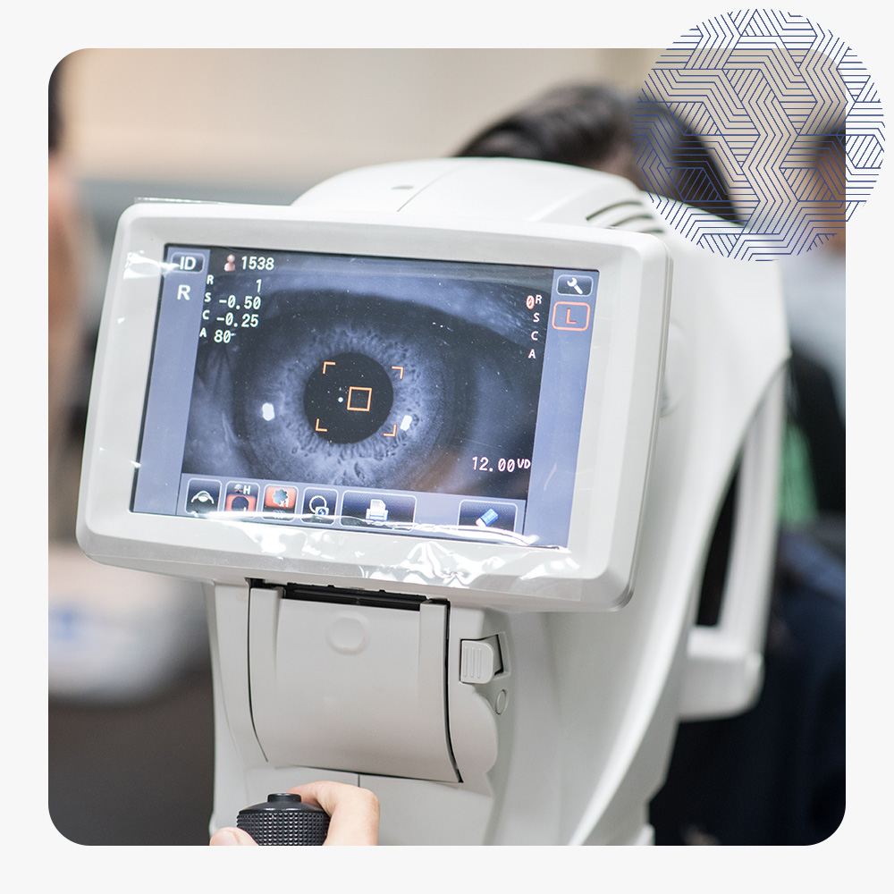 Woman looking at refractometer eye test machine in ophthalmology