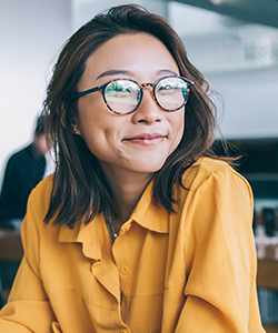smiling young asian woman sitting in a coffee shop