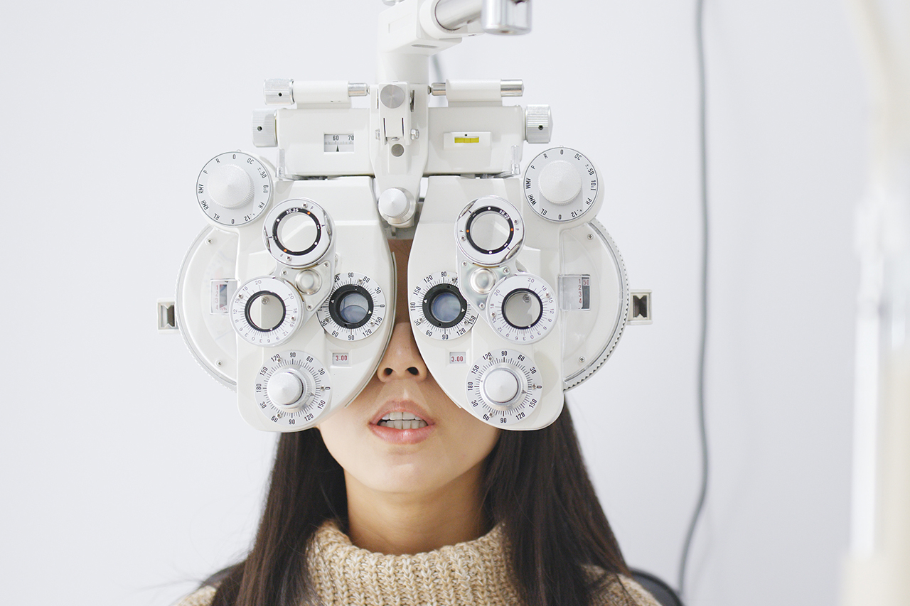Young Asian Woman doing eye test at optometric clinic