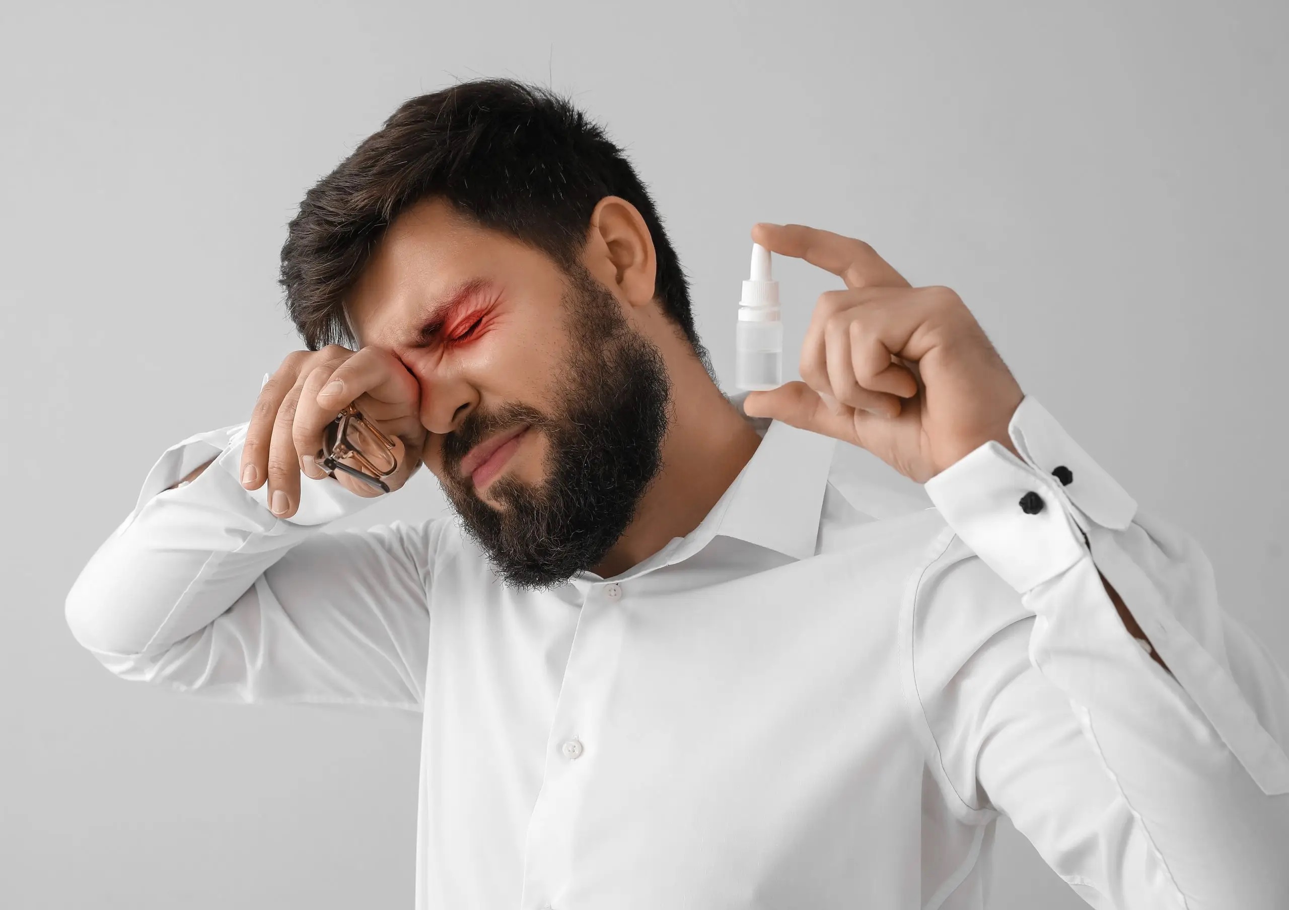 man rubbing eyes with drops scaled