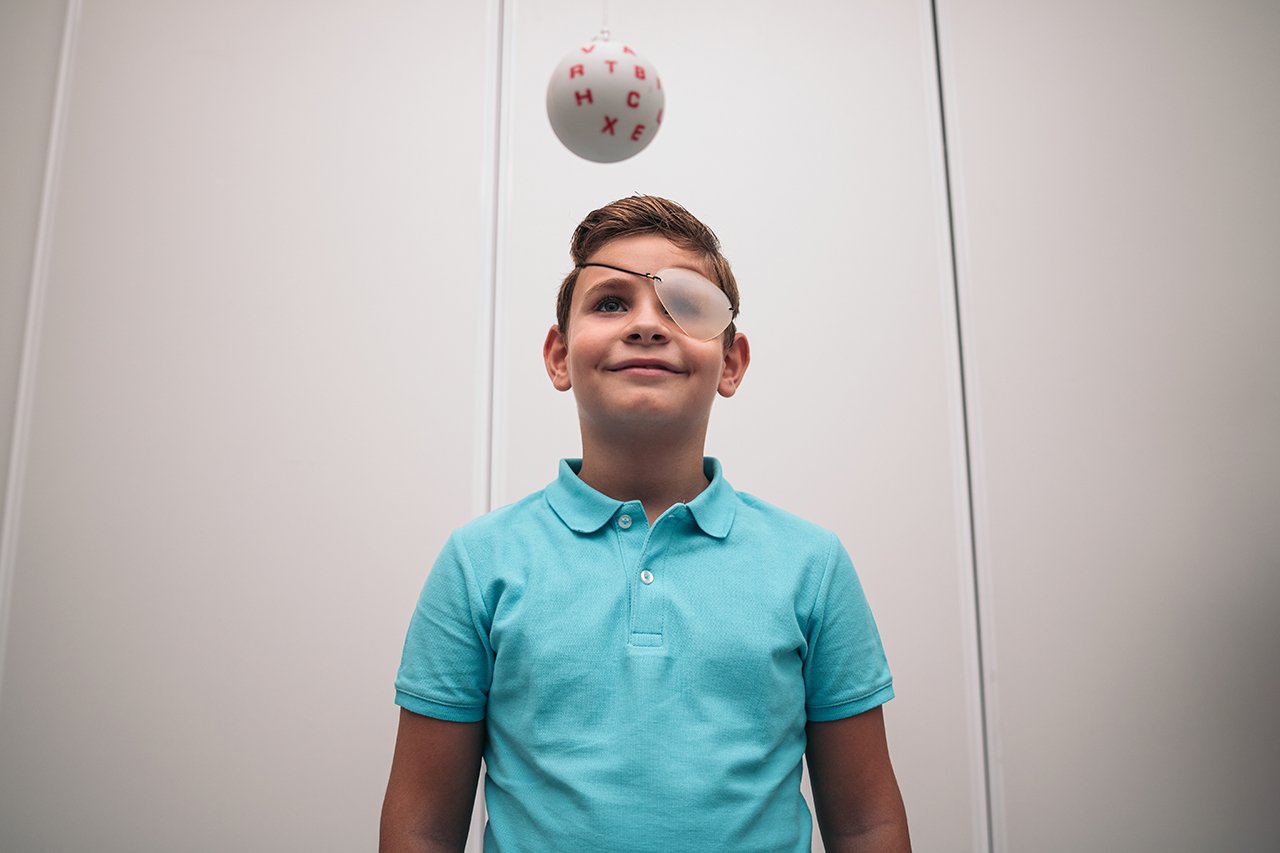 A child undergoes vision therapy in an optician. Marsden ball