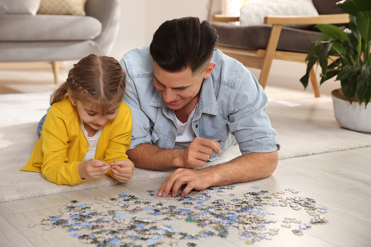 father and daughter playing with puzzle