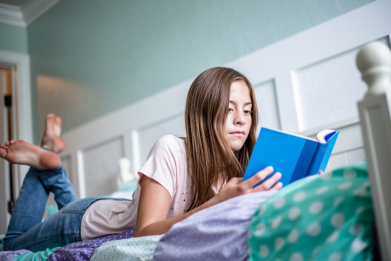 girl reading on bed