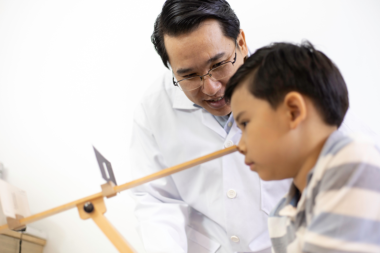 optometrist helping boy with vision therapy excercises