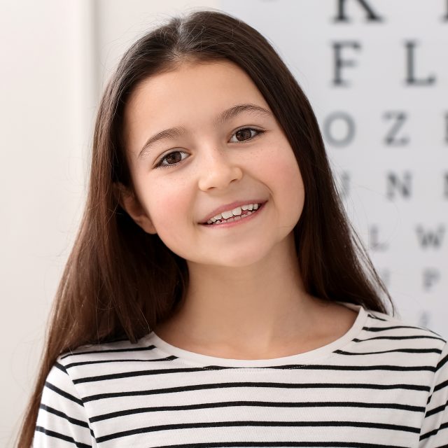 smiling young girl at eye doctor exam 640x640