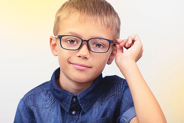 Banner little boy with glasses correcting myopia close up portrait Ophthalmology problem selective focus