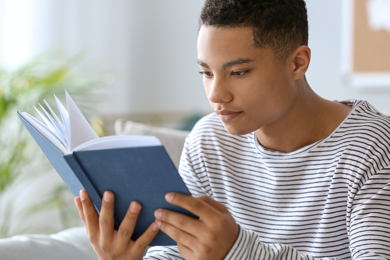 teen boy reading a book