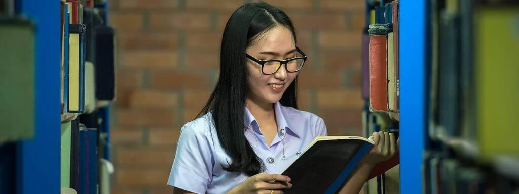 Girl wearing glasses reading in the library