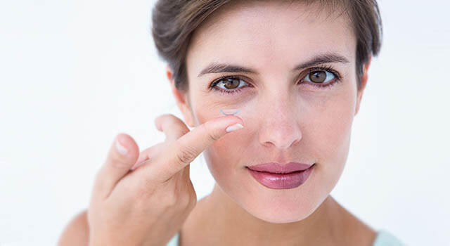 woman holding contact lens on her finger