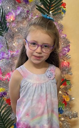 little girl blond hair wearing purple eyeglasses