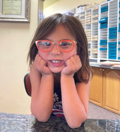 little girl wearing orange eyeglasses