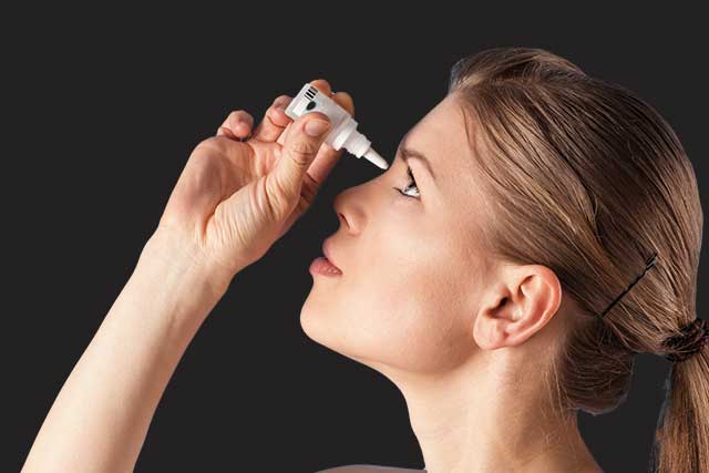Woman with dry eye, using eye drops