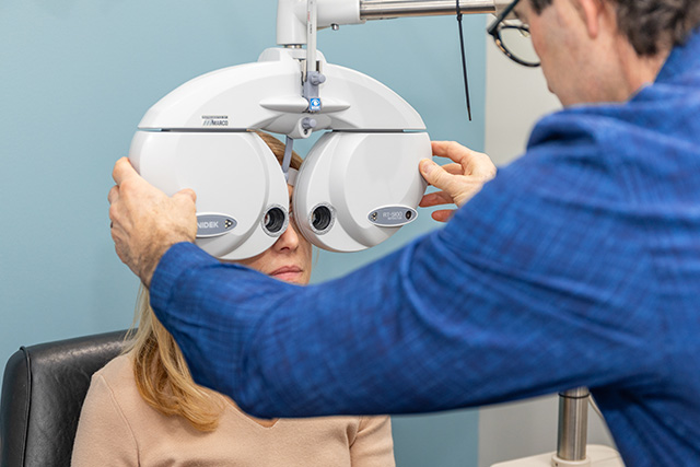 Eye doctor performing eye exam on female patient