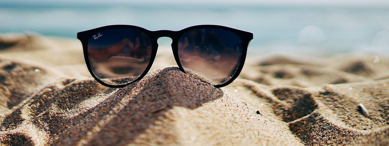 Pair of sunglasses on sand in Hemlock and Saginaw, MI