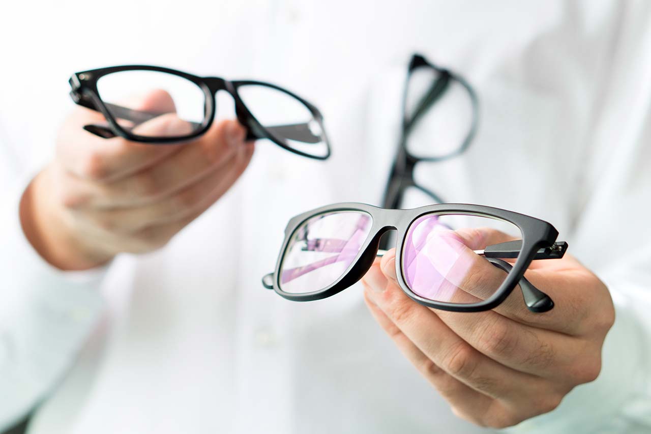 optician holding eyeglasses at Eastlake Vision Center in Chula Vista, CA