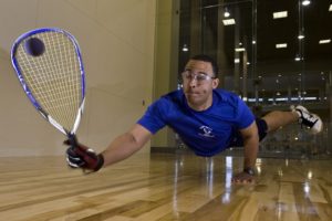 man diving while playing raquetball