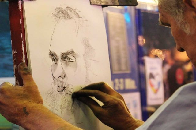 artist drawing man with no glasses