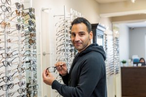 man trying on a new pair of eyeglasses 1 300x200
