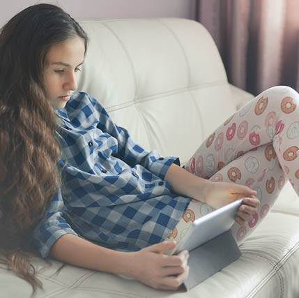 Girl with tablet, sitting on couch
