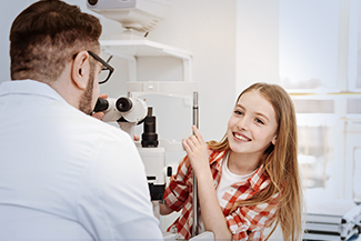 Optometrist, girl receiving eye exam with clarifye device in Akron, OH