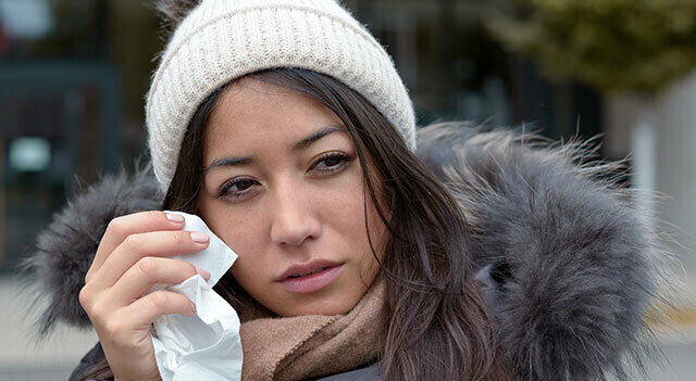 woman dabbing eyes in winter coat.jpg