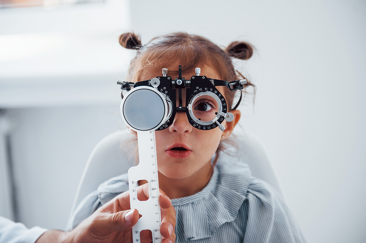 Little girl in eyewear in ophthalmology clinic have test of vision